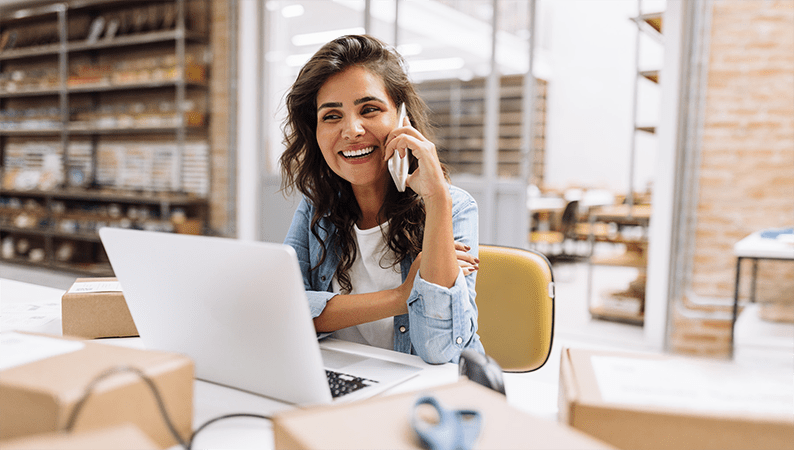 Woman on the phone next to her laptop